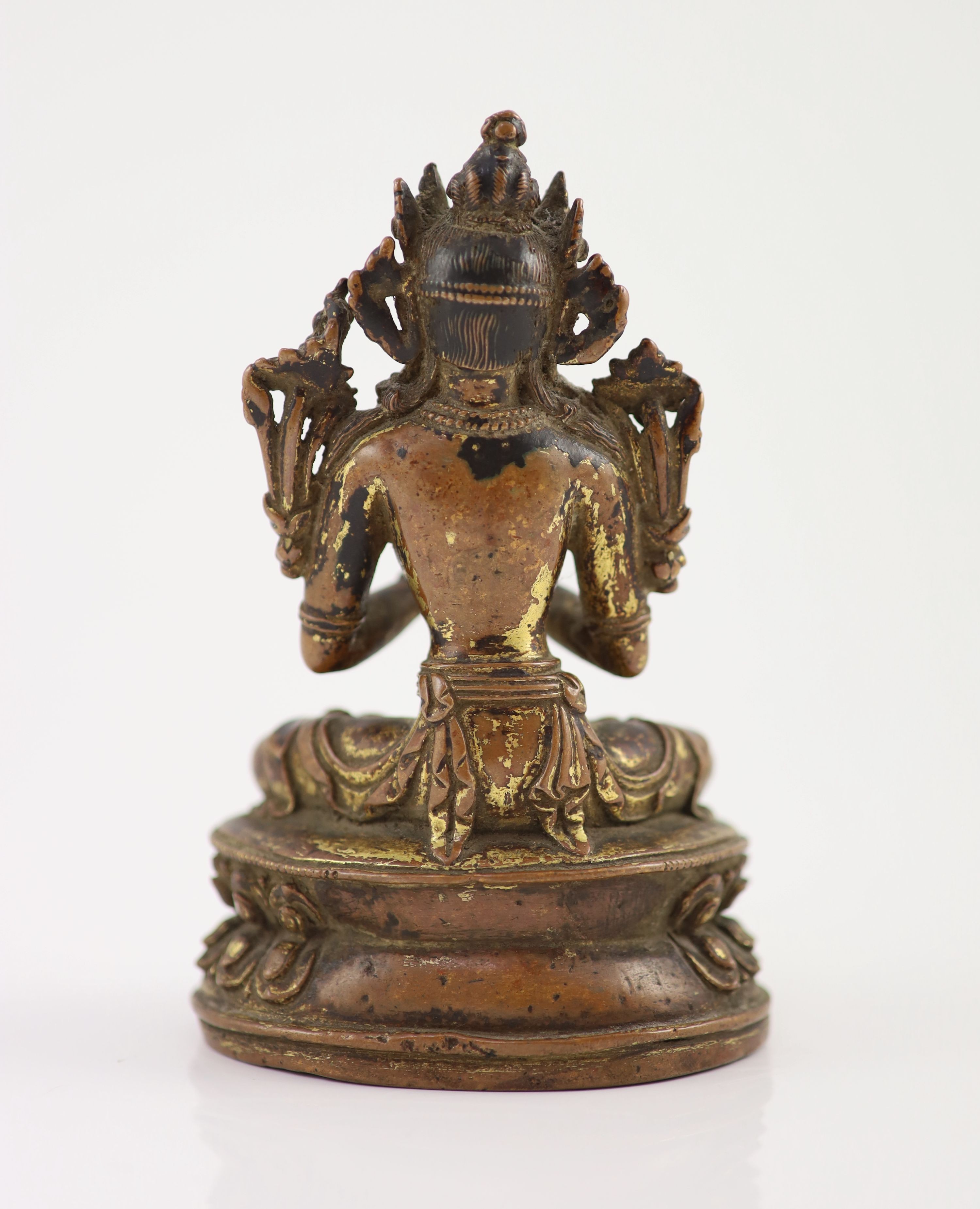 A Tibetan gilt copper alloy figure of Maitreya, 17th/18th century, 14.8cm high, worn